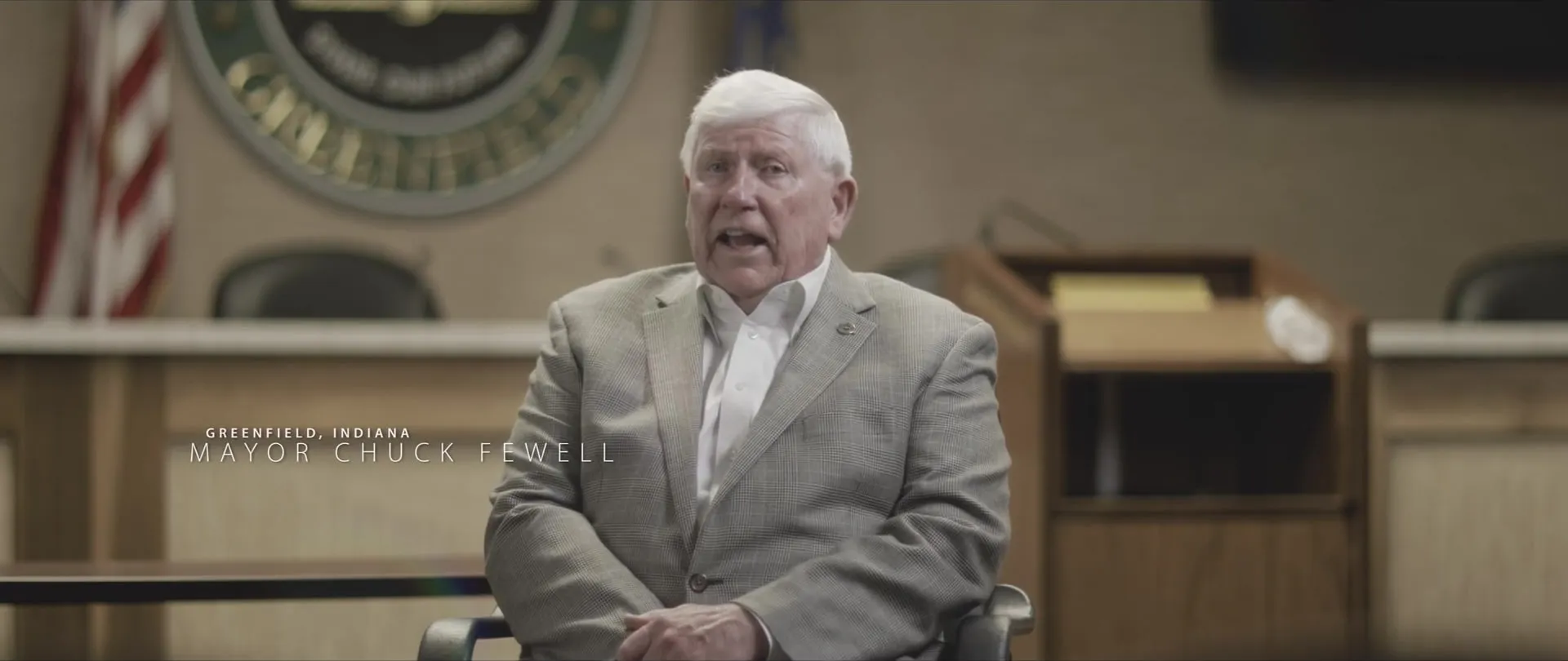 A mayor interviewed in council chambers with a lower-third title.