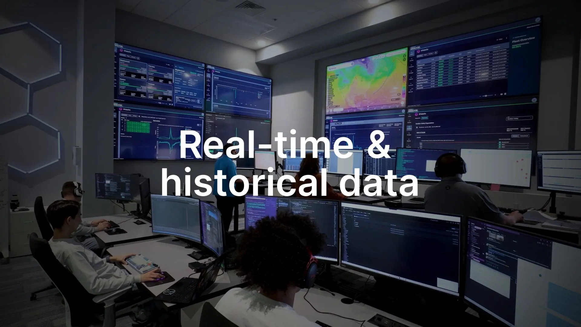 Operators at wall-sized screens in a control room under the words “Real-time & historical data”.