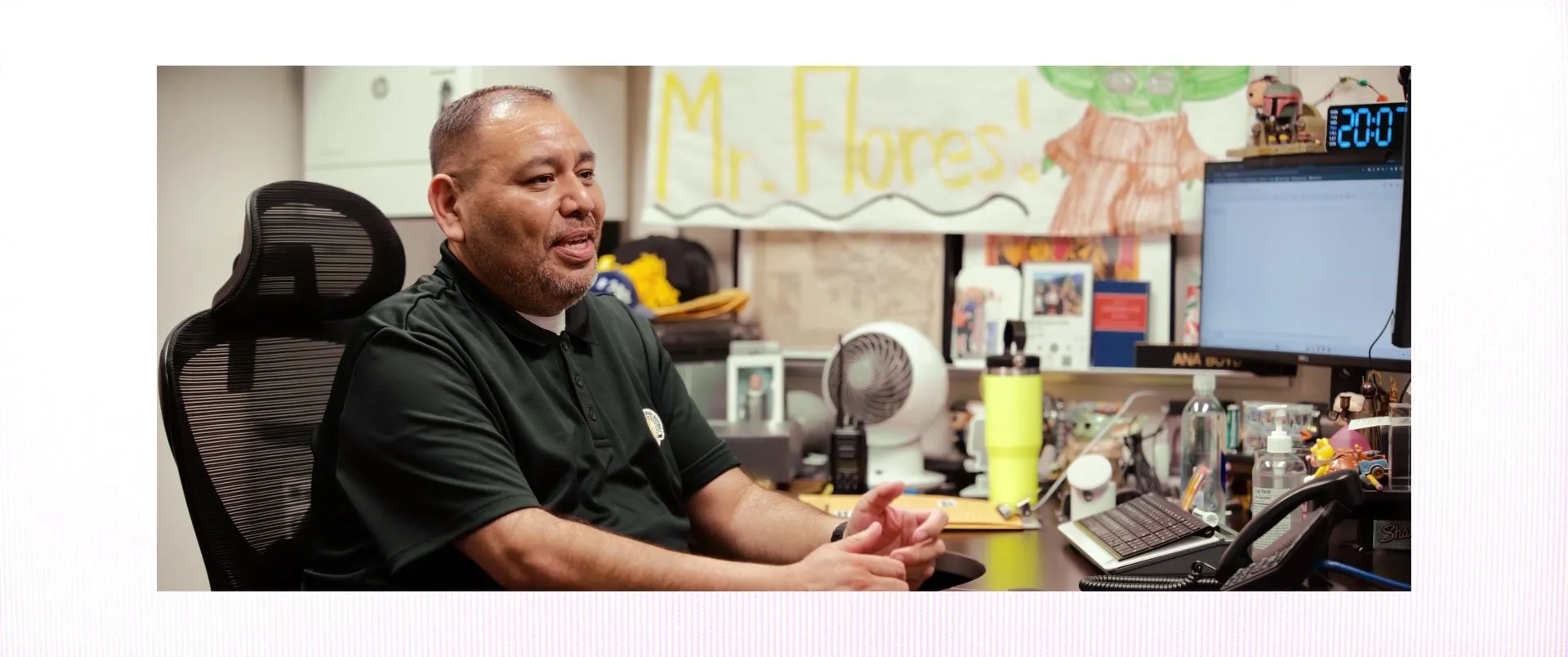 Carlos at his desk beneath a hand-drawn name sign.