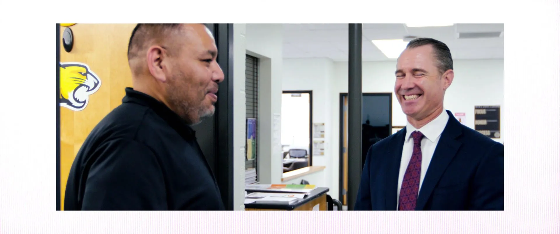 Split frame of Carlos and a visitor in a suit sharing a laugh.